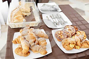 Fresh croissants on white plate. French traditional pastry. Breakfast in hotel smorgasbord.