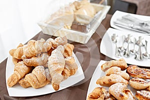Fresh croissants on white plate. French traditional pastry. Breakfast in hotel smorgasbord.