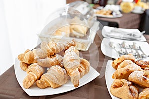 Fresh croissants on white plate. French traditional pastry. Breakfast in hotel smorgasbord.