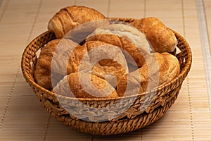 Fresh croissants in a wicker basket. Selective Focus