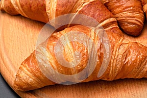 Fresh croissants on a wooden background. French pastries