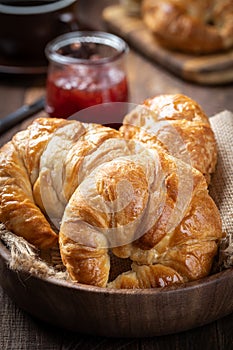 Fresh croissants in a wooden bowl