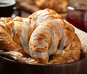 Fresh croissants in a wooden bowl