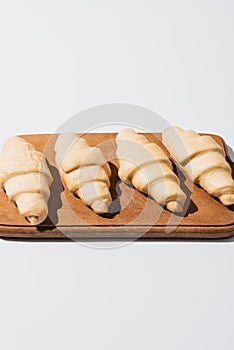 Fresh croissants on wooden cutting board