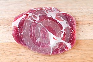 Fresh crude pork neck meat steak on wood background