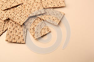 Fresh crunchy crispbreads on beige background, above view. Space for text