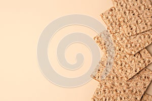 Fresh crunchy crispbreads on beige background, flat lay. Space for text