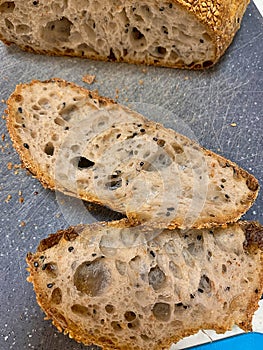 fresh crusty bread, artisan wheat bread, crispy and browned crust, sliced bread slices, grains and seeds
