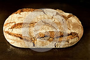 Fresh crusty german sourdough rye bread - high angle view on dark background photo