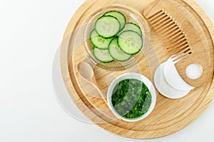 Fresh cucumber puree, cucumber slices, cotton pads and cosmetic brush. Ingredients for preparing homemade mask.