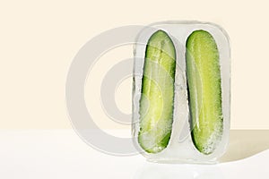 Fresh cucumber in rectangular ice. Concept of shock freezing of vegetable, frozen food. Preservation of summer vitamins. Juicy