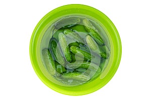 Fresh cucumbers in water in plastic bowl on white background with clipping path