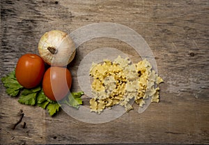 Fresh culinary ingredients for Italian pasta, mafalda, tomato, onion photo