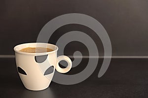 Fresh cup of coffee on dark countertop.