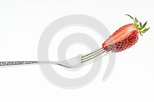 Fresh cut strawberry on fork, on white