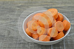 Fresh cut thick carrots on bowl on wooden