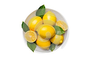Fresh cutted lemon and whole lemons over round plate isolated on white background. Food and drink ingredients preparing
