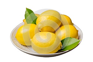 Fresh cutted lemon and whole lemons over round plate isolated on white background. Food and drink ingredients preparing