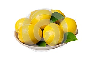 Fresh cutted lemon and whole lemons over round plate isolated on white background. Food and drink ingredients preparing