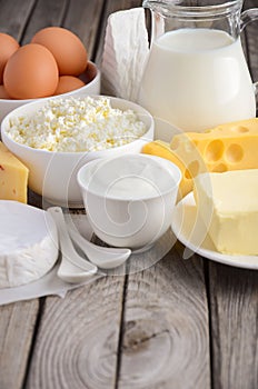 Fresh dairy products. Milk, cheese, brie, Camembert, butter, yogurt, cottage cheese and eggs on wooden table.