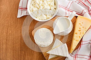 Fresh dairy products. Milk, cheese, brie, camembert and cottage cheese on the wooden background.