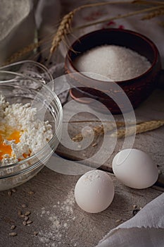 Fresh dairy products: milk, cottage cheese, sour cream, fresh eggs and wheat on rustic wooden background.
