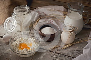 Fresh dairy products. Milk, cottage cheese, sour cream, fresh eggs and wheat on rustic wooden background.