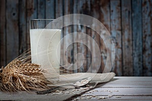 Fresh dairy products and wheat on rustic wooden background. Organic farming dairy concept