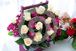 Fresh decorated bouquet of roses with box on table