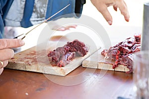 Fresh deer cutted with knife on a wooden dish