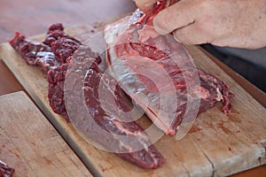 Fresh deer cutted with knife on a wooden dish.