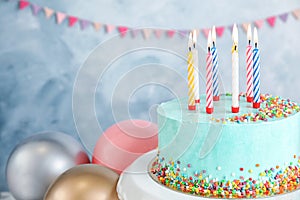 Fresh delicious birthday cake with candles near balloons on color background.