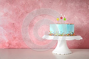 Fresh delicious birthday cake with candles on stand