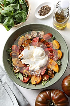 Fresh delicious burrata salad served on white table, top view photo
