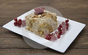 Fresh delicious diet cake with berry red currant at Dukan Diet on a porcelain plate with a spoon on a wooden background.