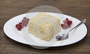 Fresh delicious diet cake with berry red currant at Dukan Diet on a porcelain plate with a spoon on a wooden background.