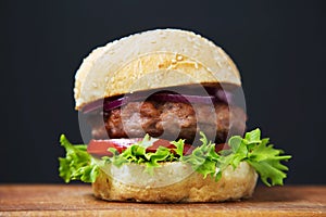 Fresh and delicious home made burger on wooden board.
