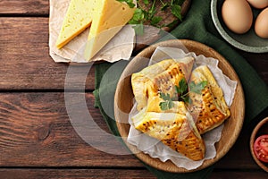 Fresh delicious puff pastry and ingredients on wooden table, flat lay. Space for text