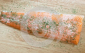 Fresh delicious salmon with parsley herbs isolated on a wooden table