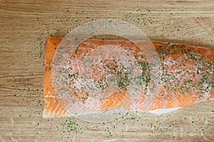 Fresh delicious salmon with parsley herbs isolated on a wooden table