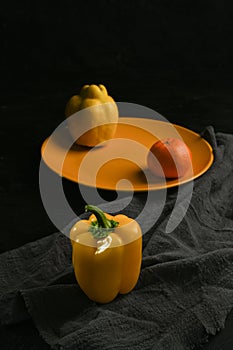fresh and delicious, yellow peppers, quince and tangerine on black background