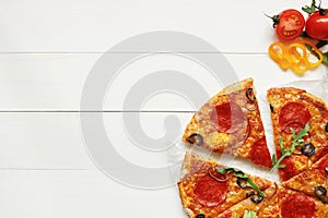 Fresh delisious sliced pizza on the wooden table with copy space, top view