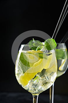Fresh detox water with mint and in glass on black table. Low key photo. Close up
