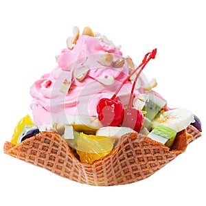 Diced fruits in waffle cone bowl with pink whipped cream and nuts decorated maraschino cherry is isolated on white