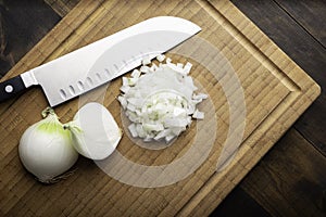 Fresh diced white onion on bamboo cutting board