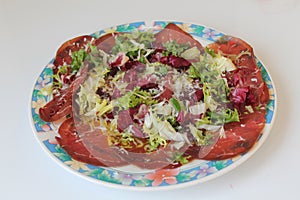 Fresh dish of bresaola, in salad