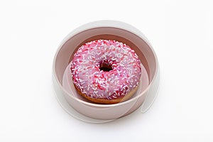 fresh donat lies in an imperious round dish on a white background