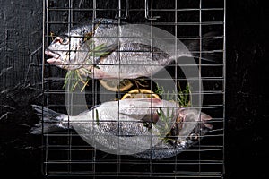 Fresh Dorada fish on a grill on a black background.