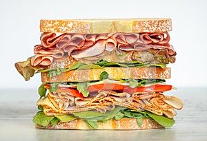 Fresh double layered sandwich with ham, lettuce, tomatoes, cheese on a toast bread. Food background