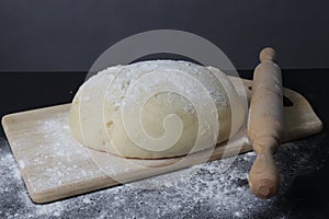 Fresh dough on a board on a black background